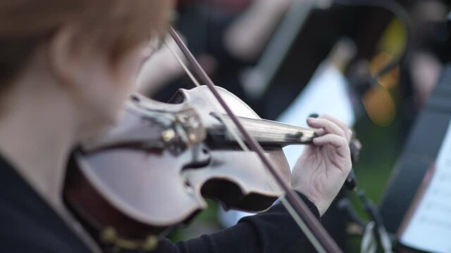 Woman violinist plays with a bow on an old vintage violin. Close-up video