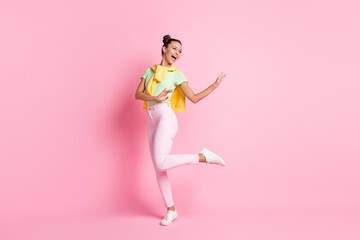 Full size photo of charming woman look empty space happy dancer isolated on pastel pink color background