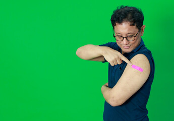 Adult senior Asian man trust and confident show shoulder with bandage plaster after getting Coronavirus of Covid-19 vaccine injection. Idea for vaccination of population against virus.