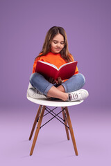 Girl reading book on chair