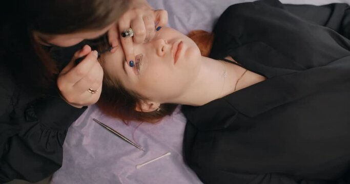 Lashmaker does the eyelash lamination procedure for the client in the beauty salon, cosmetic services, beauty care procedures, 4k 60p Prores HQ