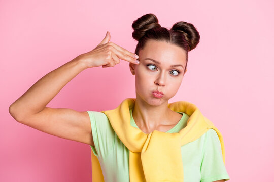 Photo of tired funky young woman hold fingers gun temple make grimace isolated on pink color background