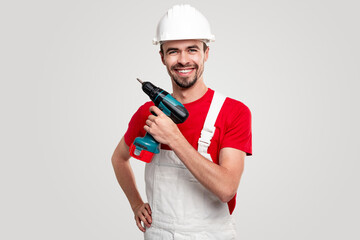 Delighted contractor with electric screwdriver - obrazy, fototapety, plakaty