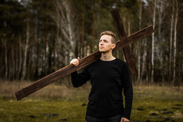 The man carries the cross. Сarry the cross. Man believes in God. Hope in God.