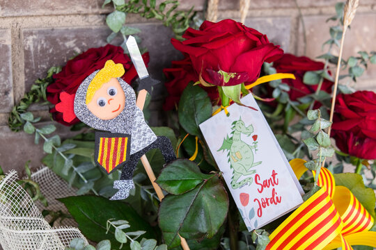 Tarragona, Spain - April 28, 2021: Roses with a Sant Jordi figurine to celebrate Sant Jordi day, the day of the book and the rose in Catalonia.