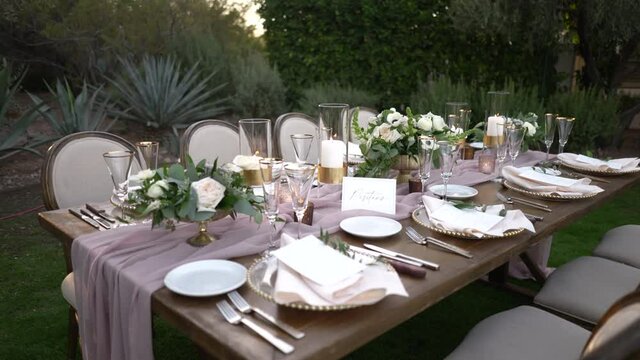 Stylish Outdoor Dinner Party. Decorated Table with beautiful flower bouquets. 