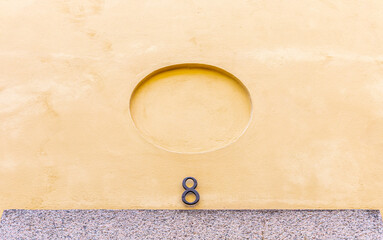 House number above the entrance on yellow facade