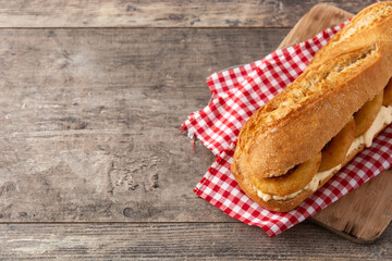 Calamari rings sandwich on wooden table. Copy space