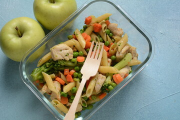 Lunch box with pasta salad, baked vegetables and fried pieces of chicken breast . Healthy lunch concept.