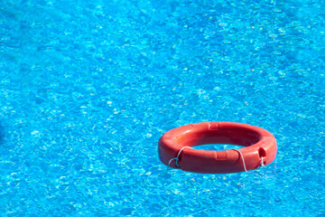 red lifebuoy floating in hotel pool with beautiful blue water