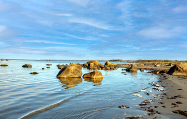 View of a beautiful coastal landscape with rocks, beach, and blue skies. 