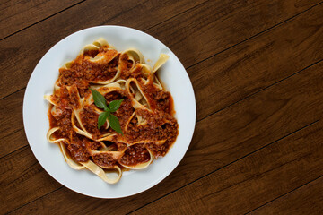 Pasta with bolognese sauce and basil leaves. Photography of Macaroni. Italian gastronomy. Top view photo with free spaces for texts.