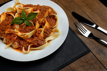 Pasta tagliatelle with bolognese sauce and basil leaves. Popular food of Italian origin....