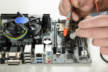 A technician checks the serviceability of the computer motherboard.