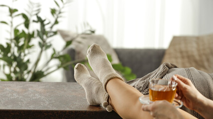 Woman legs on table and home interior. 