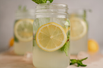 three Lemon mojito cocktail with mint in mason jars on top of wood. lemon mojito