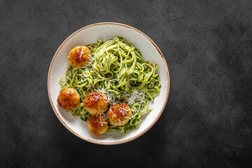 Chicken meatballs with spaghetti and green kale cashew pesto sauce, top view