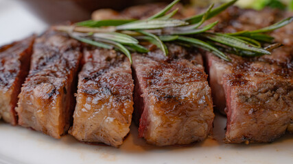 Close up view on serving of marinated grilled rib eye steak with baked potatoes and vegetables.