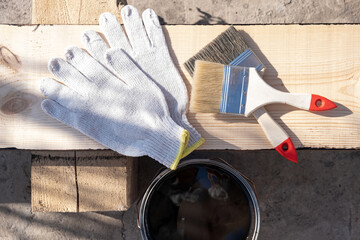 Painting a wooden board outdoors. Coated with protective oil against decay and moisture.