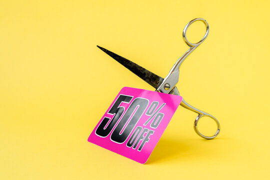 Metal scissors cutting the price tag