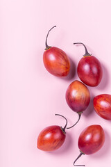 Tamarillo fruit on pink pastel paper background