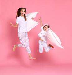 Excited mother and daughter jumping in morning