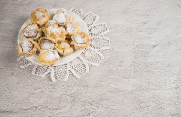 Traditional Portuguese homemade puff pastry with egg cream on a light table with a lace napkin. Dessert Pasteis de nata.