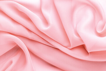 light pink fabric draped with large folds, delicate textile background