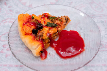 pizza slice with tomato ketchup in a plate