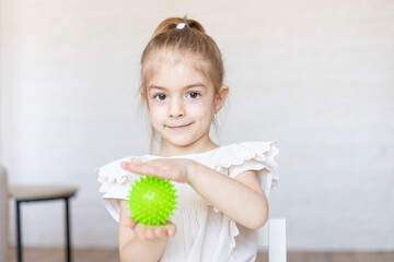 Child make exercise with relief ball for  tactile sensory. - obrazy, fototapety, plakaty