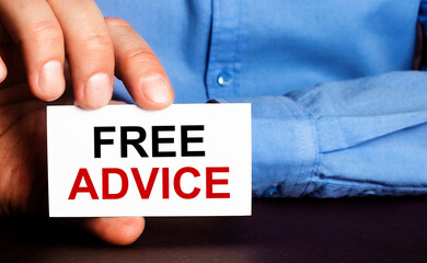 FREE ADVICE is written on a white business card in a man's hand. Advertising concept
