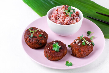 Tofu cutlets with chickpea and boiled rice served on ceramic plate on white table. Asian vegan meal
