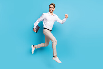 Fototapeta na wymiar Full body profile side photo of cheerful young happy man go empty space hold laptop isolated on blue color background