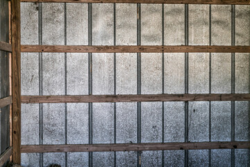 A Grid metal and wood exterior wall taken from the interior