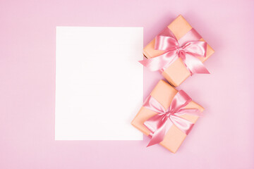Blank paper and gifts. Gifts with bows on a pink background