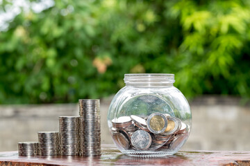 coins growing up on stacks money on wooden and green bokeh, money growth concept,saving concept.