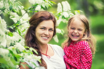 Portrait of happy mother and little daughter in spring park