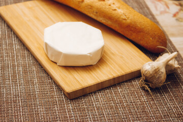 moldy cheese on a paper packaging. camembert in white paper packaging on the kitchen table