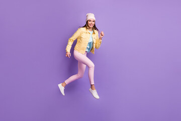 Fototapeta na wymiar Full length body size photo of young woman jumping running fast isolated on vivid purple color background