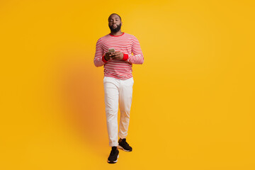 Portrait of serious man hold telephone on yellow background