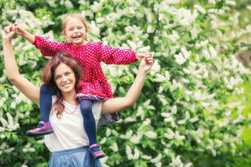 Portrait of happy mother and little daughter in spring park