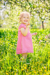 Happy little girl playing in sunny spring garden
