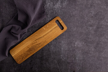 Long wooden cutting board on dark background