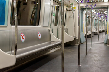 Interior of an empty seats of metro rail carriage with red cross mark. Social distancing symbol...