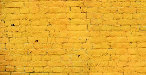 Yellow brick wall with peeling paint