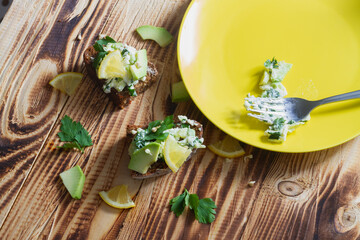 Make avocado paste sandwiches with sprouted green buckwheat and lemon on rye bread with a fork