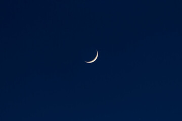 Obraz na płótnie Canvas Waxing crescent moon in a dark blue night sky