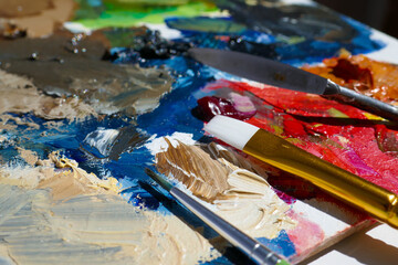 Palette with paint strokes and brushes