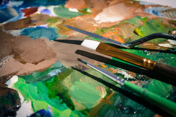 Palette with paint strokes and brushes