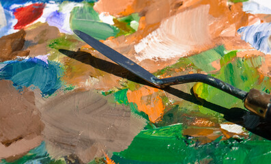 Palette with paint strokes and brushes